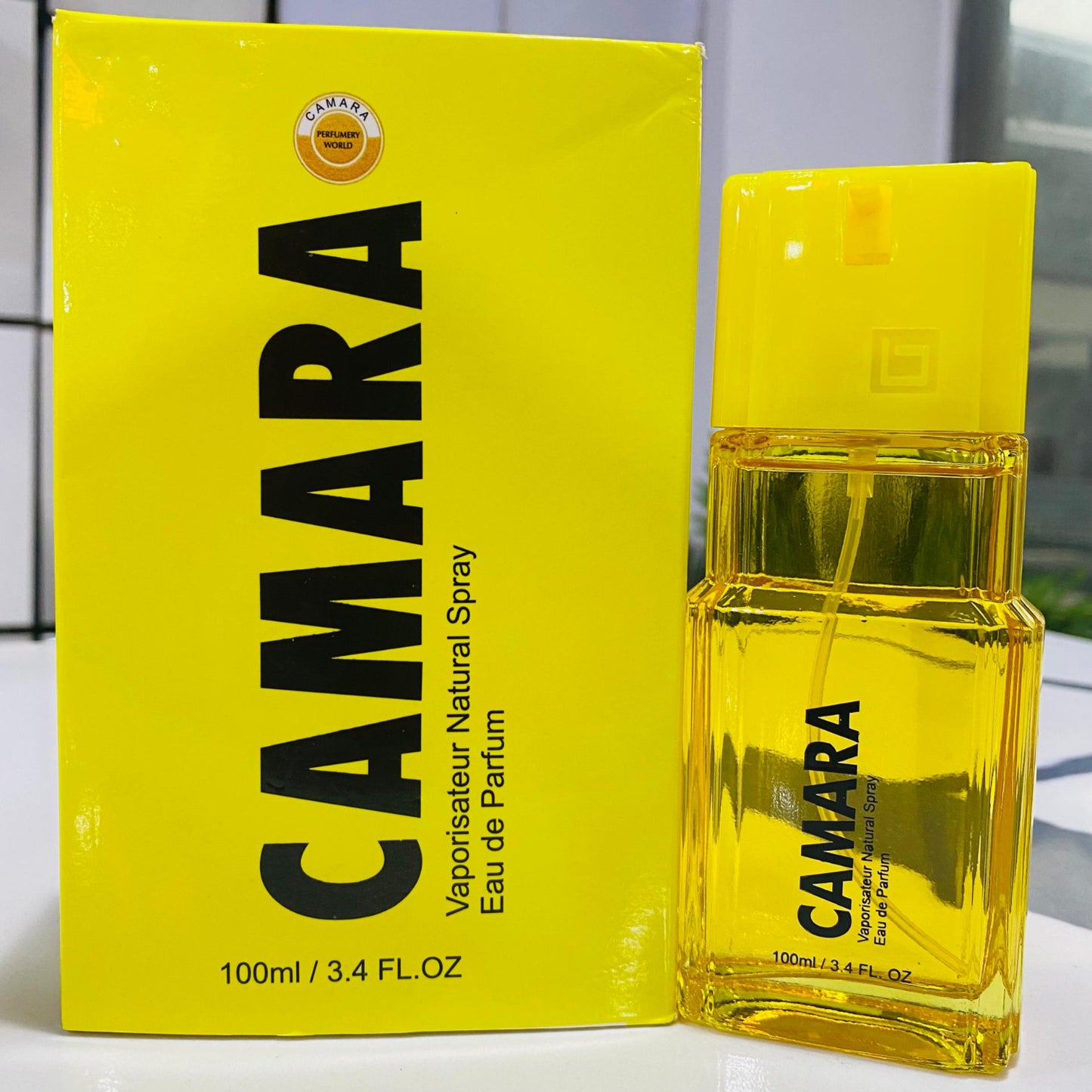 Yellow Camara perfume bottle and packaging on a white background