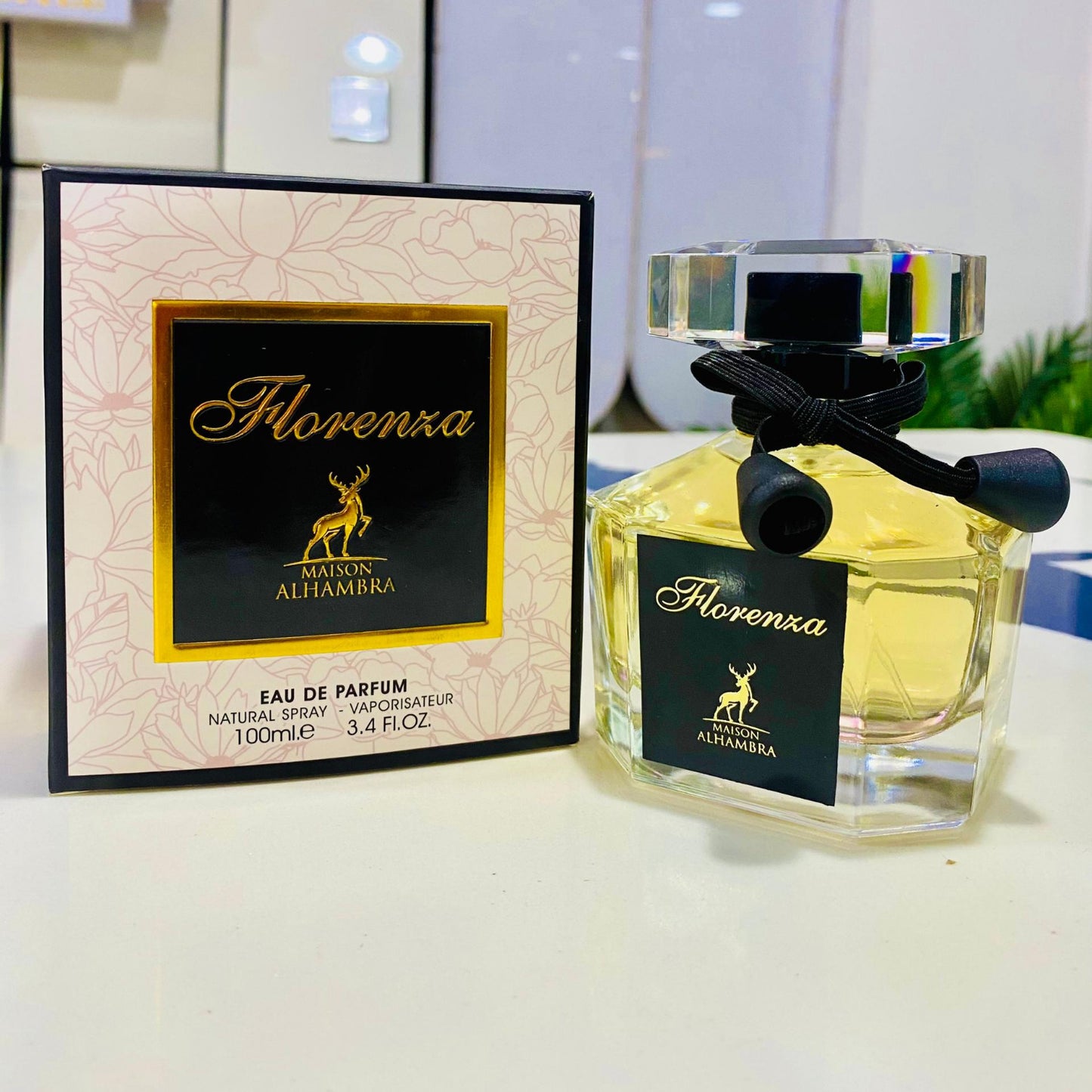 Florenza Alhambra perfume bottle and packaging on a reflective surface with blurred background