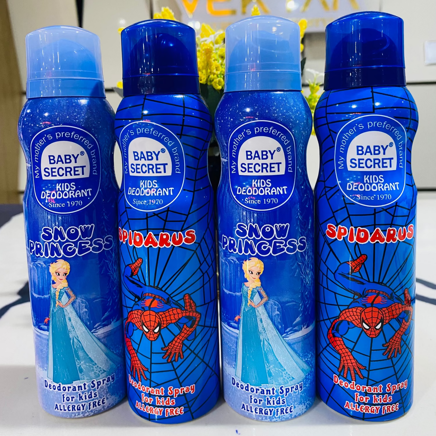 Four bottles of Baby Secret Kids Deodorant with Spider-Man and Frozen designs on a white surface.