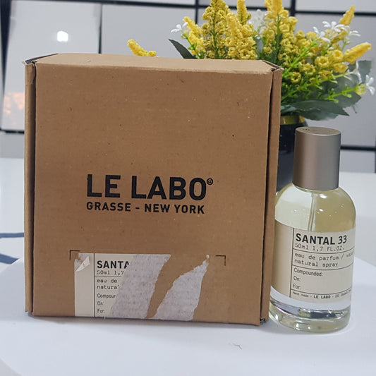 LE LABO bottle and box with yellow flowers on a white surface