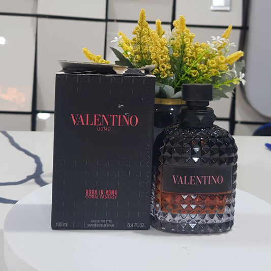 Vektor perfume bottle and packaging on a table with a decorative plate in the background.