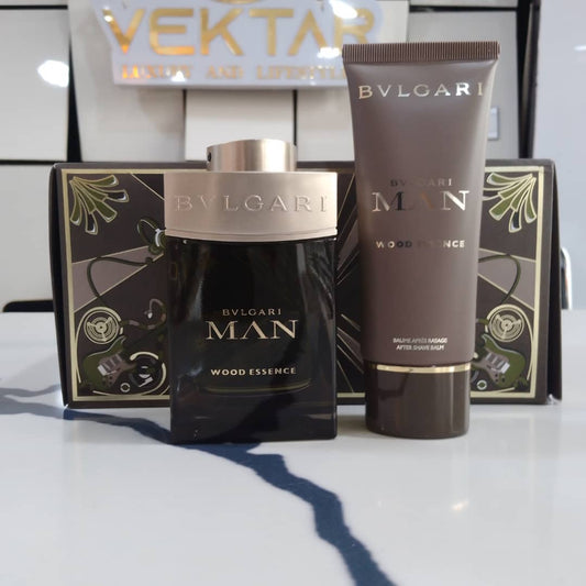 Bulgari Man Wood Essence perfume and after-shave balm on a white surface with a blurred background.