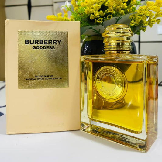 Burberry Goddess perfume bottle and packaging with a bouquet of yellow flowers in the background.