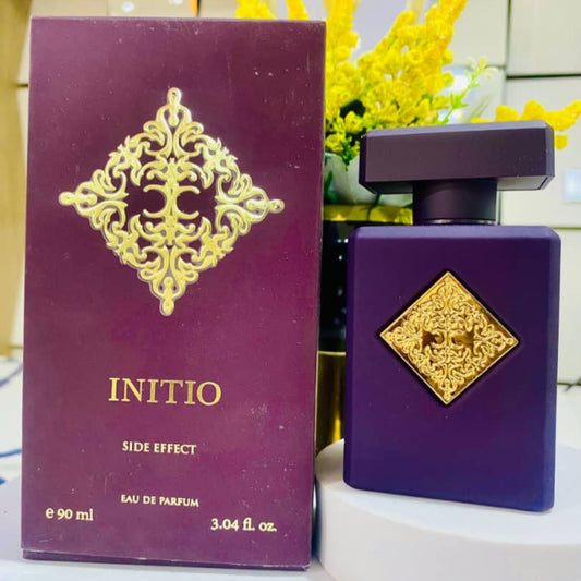 Purple perfume bottle and packaging with gold accents on a white surface.