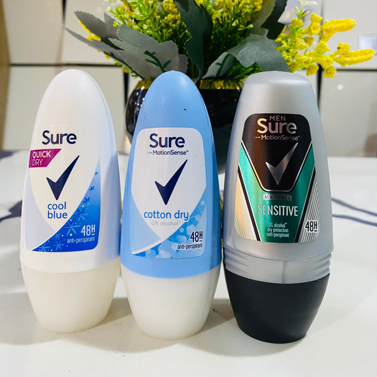 Three deodorant rolls from the brand 'Sure' with a decorative flower arrangement in the background.