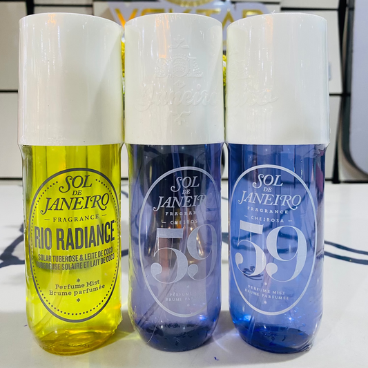Three bottles of Sol de Janeiro fragrances on a reflective surface with a blurred background.