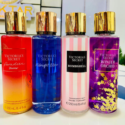 Four Victoria's Secret fragrances bottles in different colors on a white surface.
