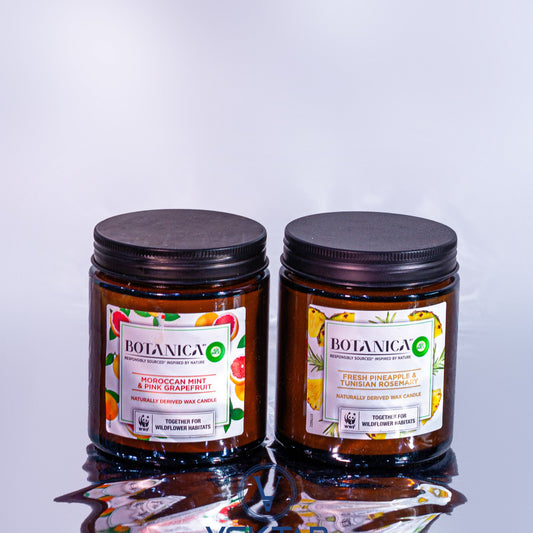 Two Botanica candles with labels on a white background
